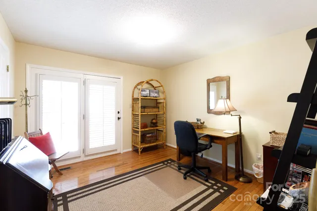 a view of a workspace with furniture and a window