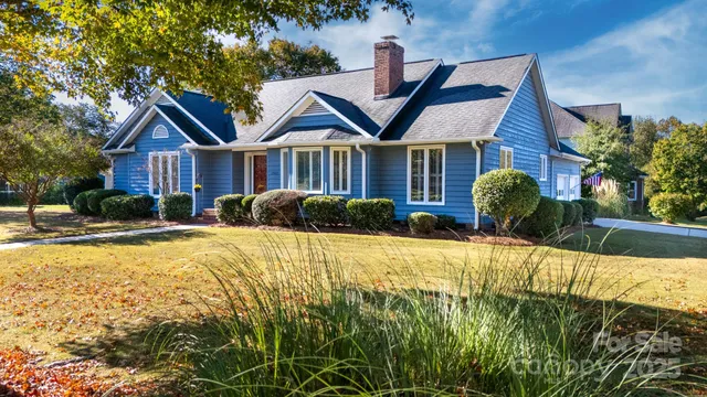 a front view of a house with a yard and trees