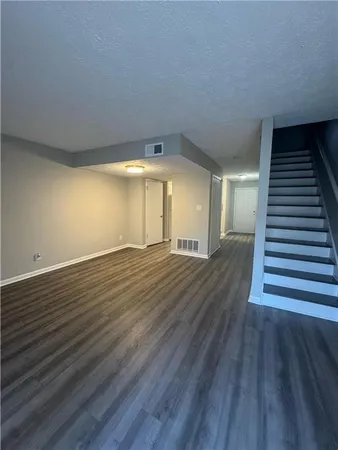 a view of a room with wooden floors and stairs