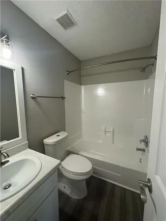a bathroom with a toilet a sink and shower
