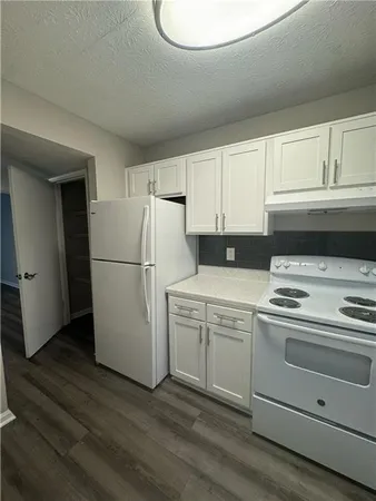 a kitchen with a refrigerator stove and white cabinets