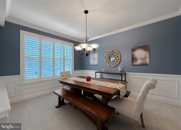 a dining room with wooden floor a chandelier a wooden table and chairs
