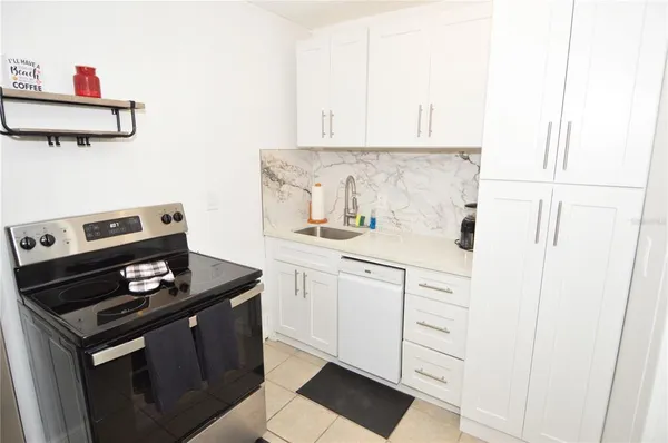 a kitchen with a stove and white cabinets