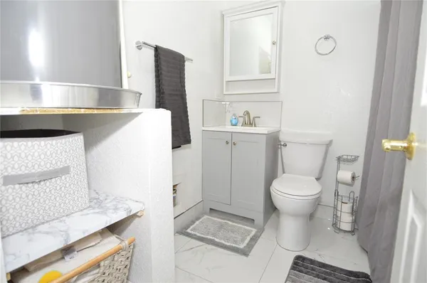 a bathroom with a sink toilet and mirror
