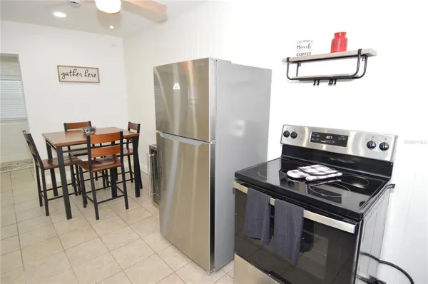 a kitchen with stainless steel appliances granite countertop a stove a refrigerator and a dining table