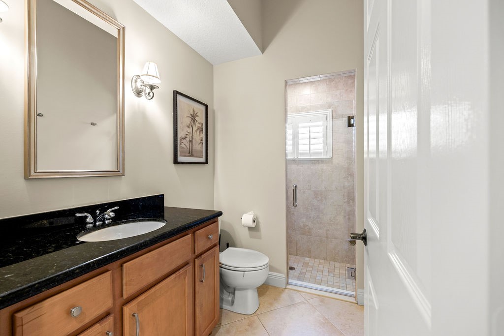 2134 Northwest Tilia Trail Stuart, FL 34994 - Photo 21 of 36 a bathroom with a toilet a sink a mirror a shower a vanity and window