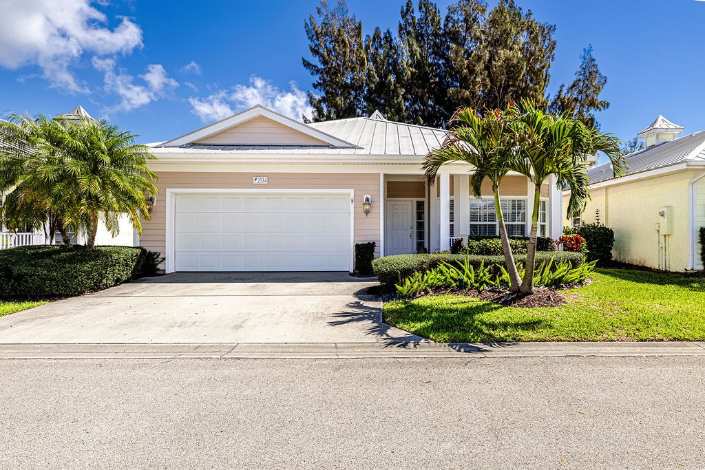 2134 Northwest Tilia Trail Stuart, FL 34994 - Photo 22 of 36 a front view of a house with a garden and potted plants