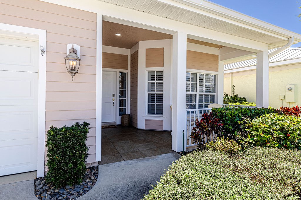 2134 Northwest Tilia Trail Stuart, FL 34994 - Photo 27 of 36 a house with potted plants in front of door