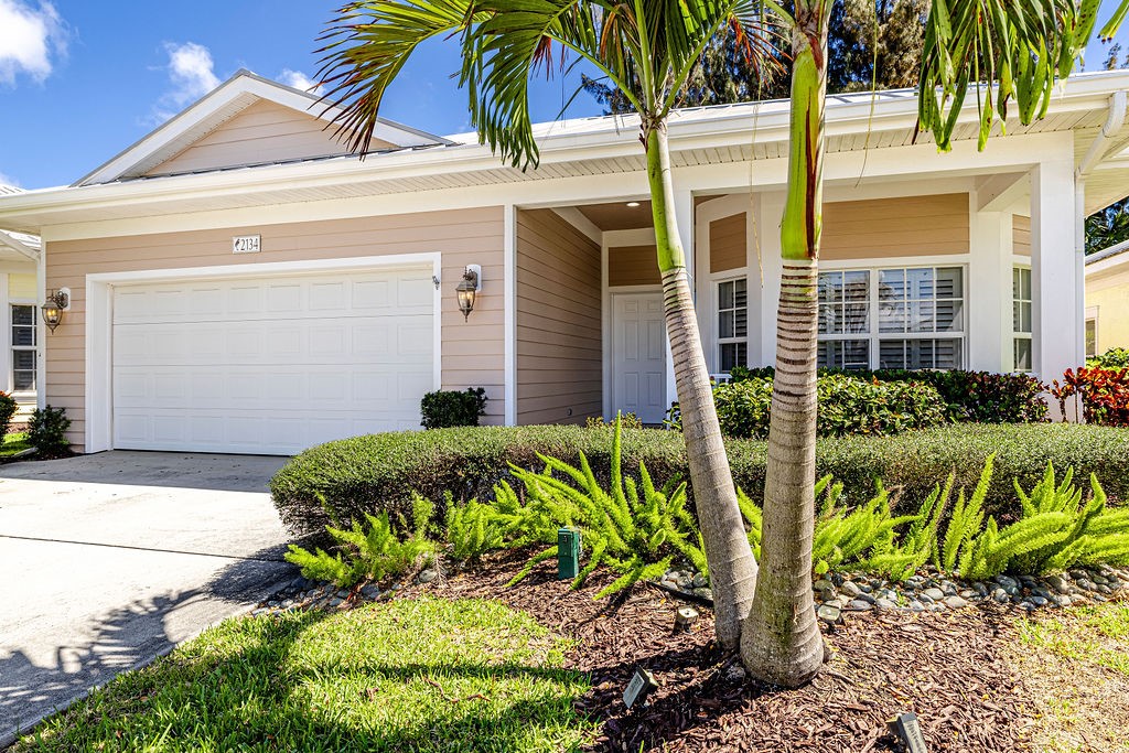 2134 Northwest Tilia Trail Stuart, FL 34994 - Photo 29 of 36 a front view of a house with a garden