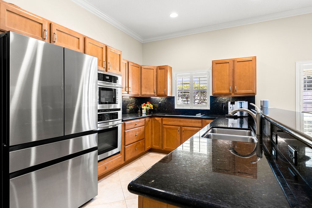2134 Northwest Tilia Trail Stuart, FL 34994 - Photo 6 of 36 a kitchen with stainless steel appliances granite countertop a refrigerator a sink and a stove