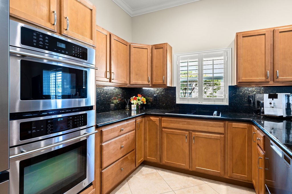 2134 Northwest Tilia Trail Stuart, FL 34994 - Photo 9 of 36 a kitchen with granite countertop cabinets stainless steel appliances and a window