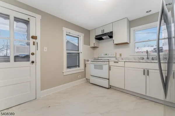 a kitchen with white cabinets and white appliances