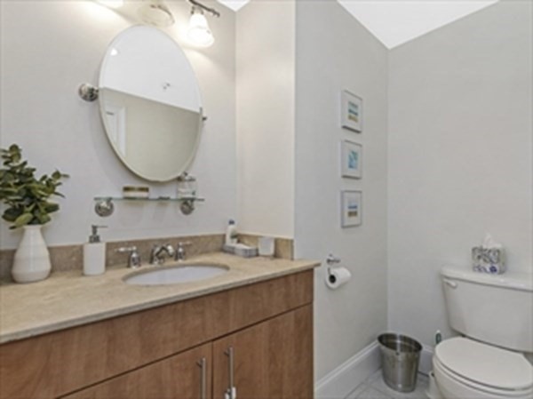 2025 Commonwealth Avenue, Unit 5 Boston, MA 02135 - Photo 11 of 13 a bathroom with a granite countertop toilet sink and mirror