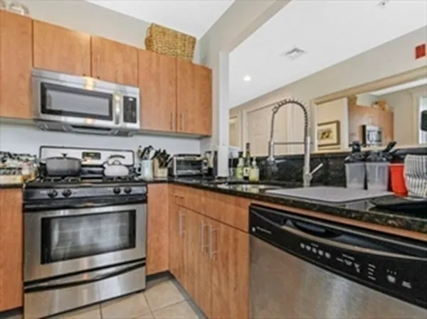 a kitchen with stainless steel appliances granite countertop a stove microwave and sink