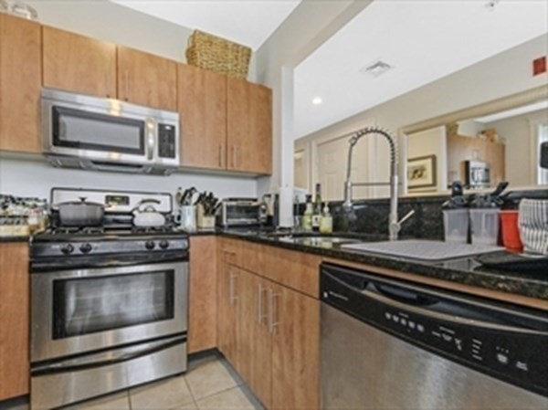 2025 Commonwealth Avenue, Unit 5 Boston, MA 02135 - Photo 5 of 13 a kitchen with stainless steel appliances granite countertop a stove microwave and sink