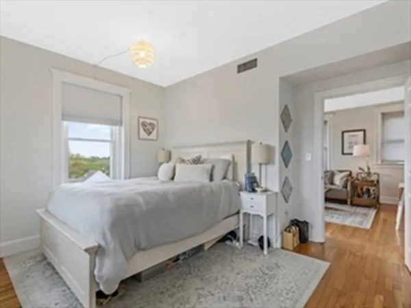 a bedroom with a bed and wooden floor
