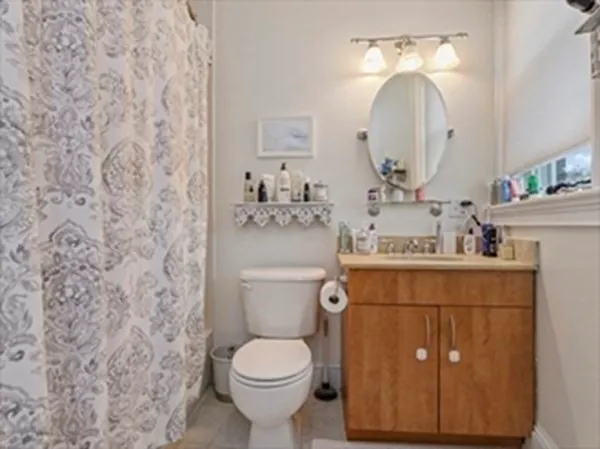 a bathroom with a granite countertop toilet sink and mirror