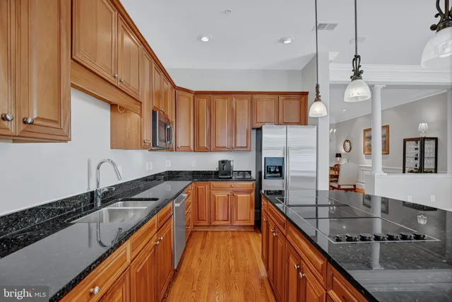 a kitchen with granite countertop a sink a counter space appliances and cabinets