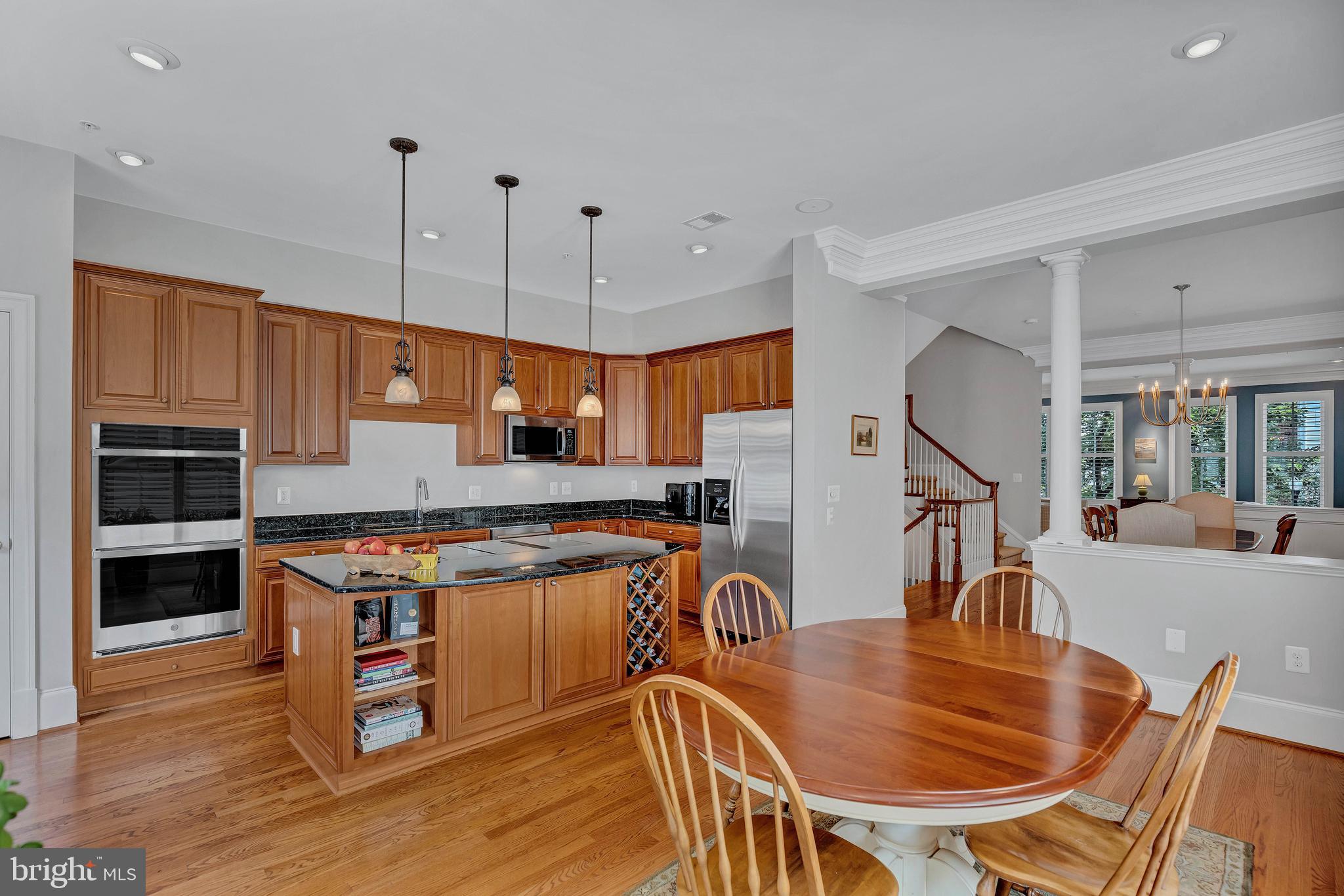 708 Day Lane Alexandria, VA 22314 - Photo 9 of 39 a kitchen with stainless steel appliances granite countertop a stove a refrigerator a kitchen island a dining table and chairs with wooden floor