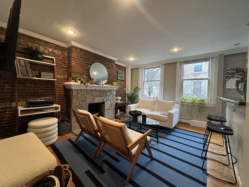 41 Grove Boston Ma, Unit 4 Boston, MA 02114 - Photo 2 of 20 a living room with furniture a flat screen tv and a fireplace