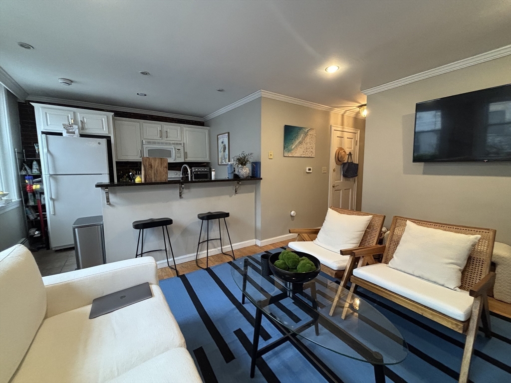 41 Grove Boston Ma, Unit 4 Boston, MA 02114 - Photo 5 of 20 a living room with furniture a flat screen tv and kitchen view