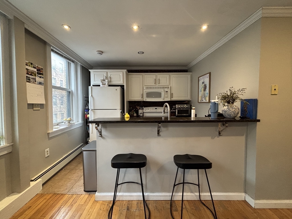 41 Grove Boston Ma, Unit 4 Boston, MA 02114 - Photo 6 of 20 a kitchen with stainless steel appliances granite countertop a stove a sink and a microwave