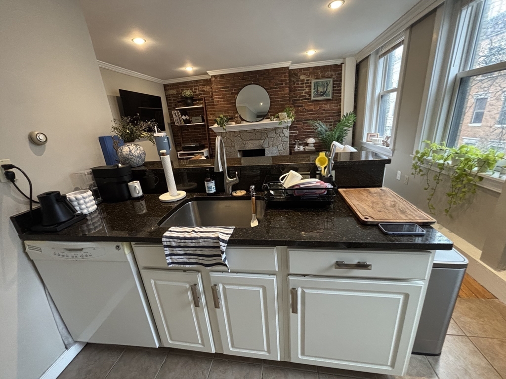 41 Grove Boston Ma, Unit 4 Boston, MA 02114 - Photo 9 of 20 a kitchen with kitchen island granite countertop a sink cabinets and wooden floor