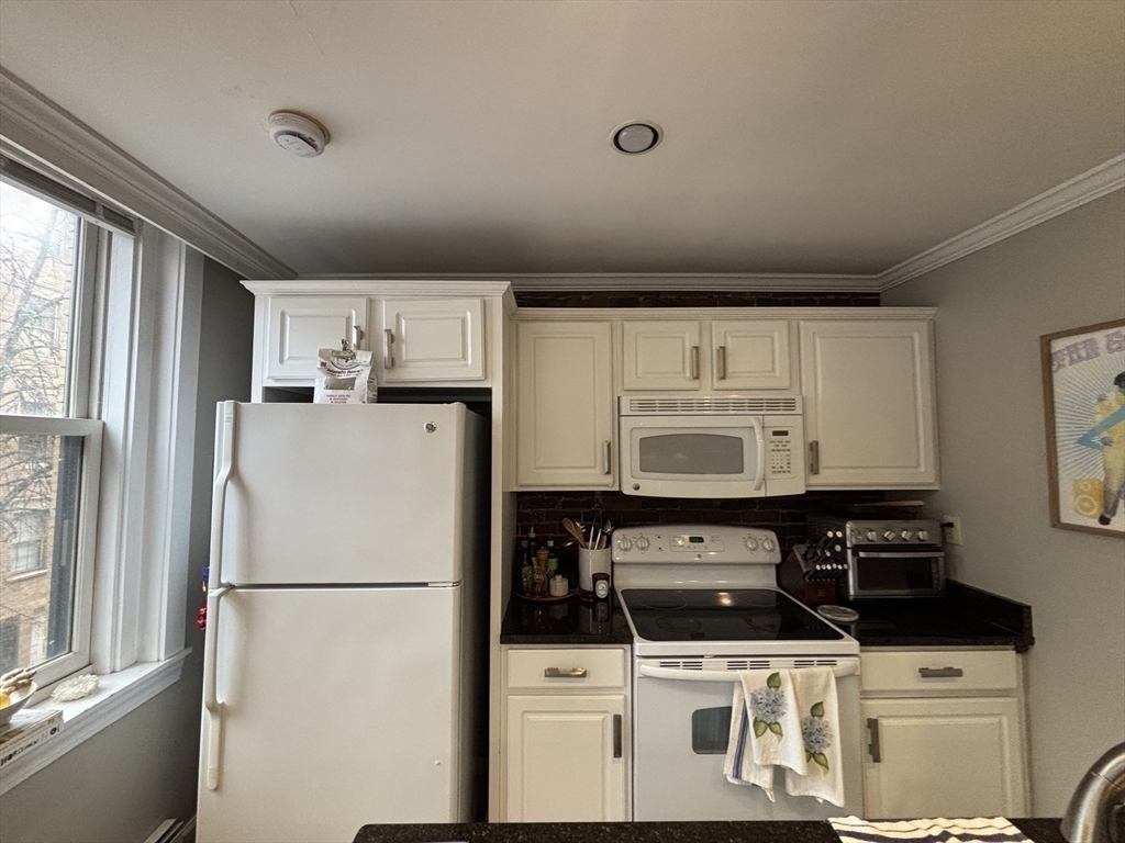 41 Grove Boston Ma, Unit 4 Boston, MA 02114 - Photo 10 of 20 a white refrigerator freezer and a stove sitting inside of a kitchen
