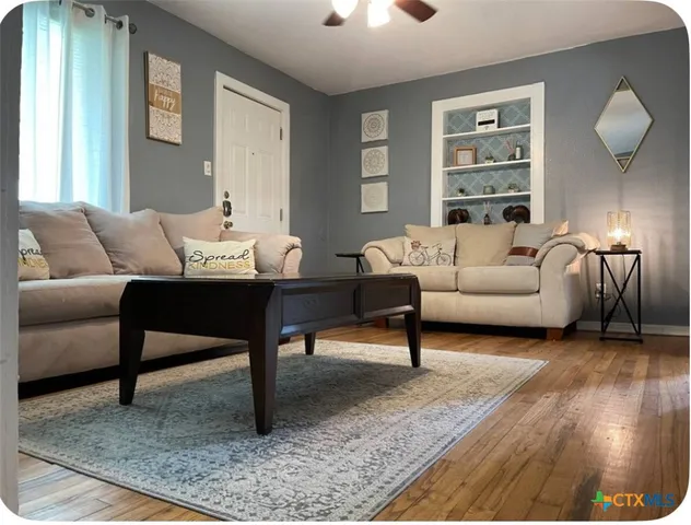 a living room with furniture lamp and window