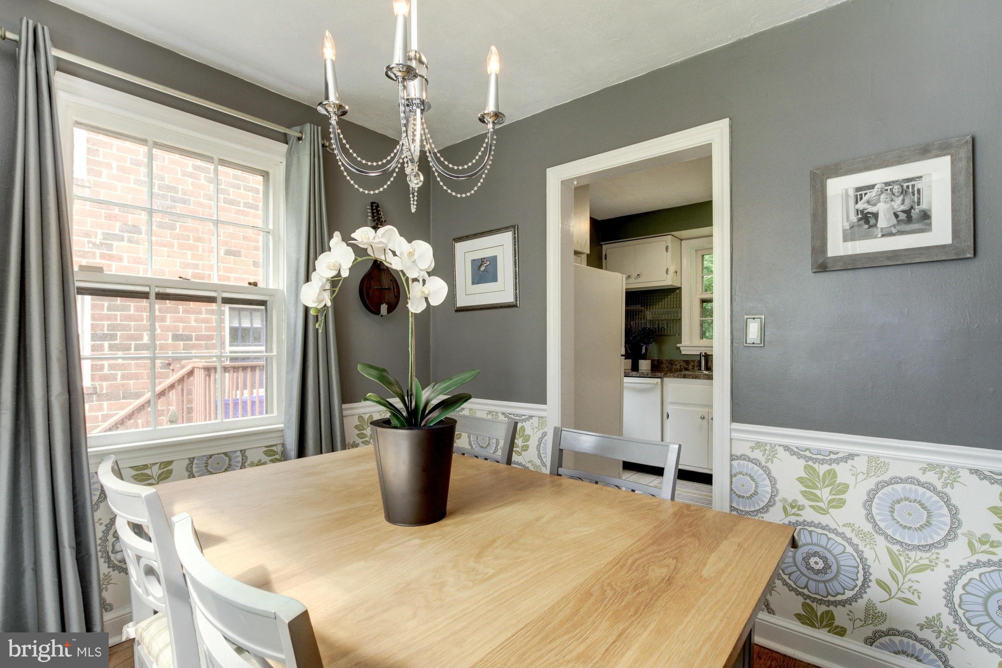 9917 Big Rock Road Silver Spring, MD 20901 - Photo 7 of 24 a dining room with wooden floor a chandelier a wooden table and chairs