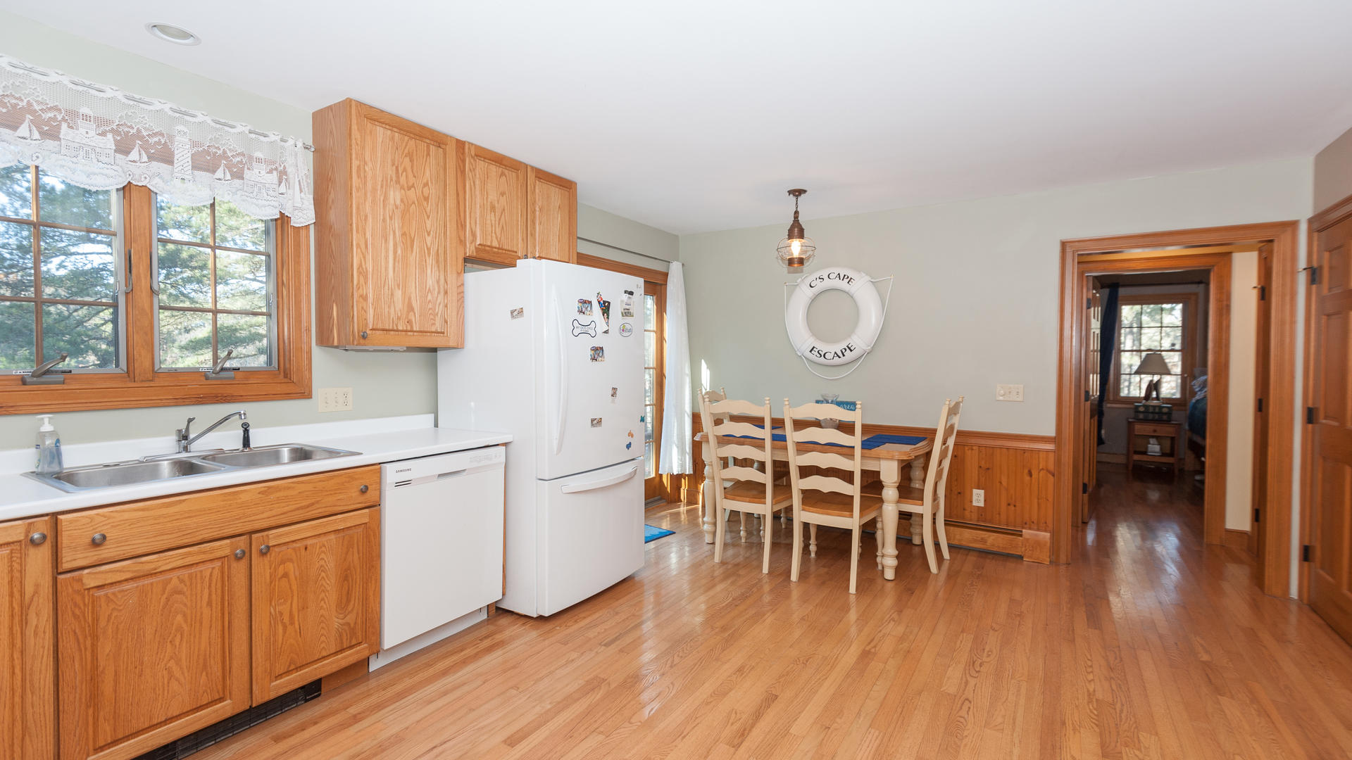 1670 Bridge Road Eastham, MA 02642 - Photo 3 of 12 a dining room with stainless steel appliances granite countertop a kitchen island hardwood floor a sink and a window