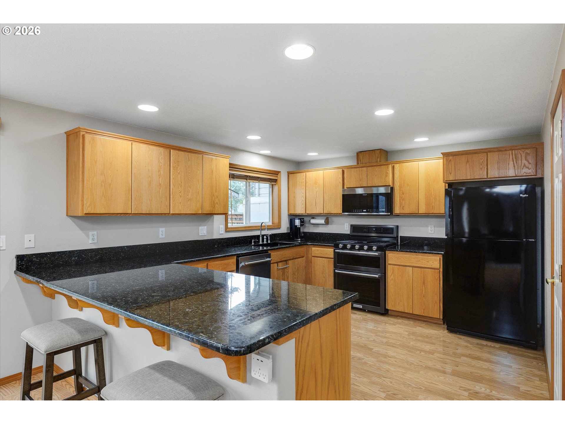 2366 Baines Boulevard Hubbard, OR 97032 - Photo 13 of 48 a kitchen with stainless steel appliances granite countertop a sink a stove top oven a dining table and chairs