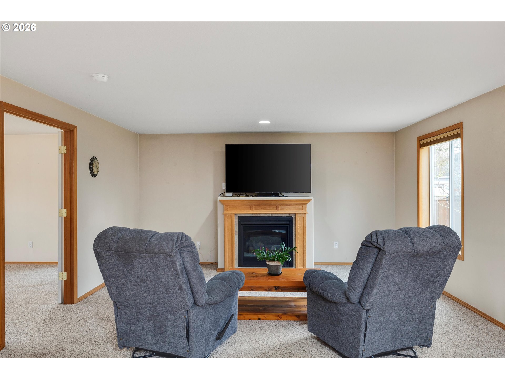 2366 Baines Boulevard Hubbard, OR 97032 - Photo 18 of 48 a living room with furniture a fireplace and a flat screen tv