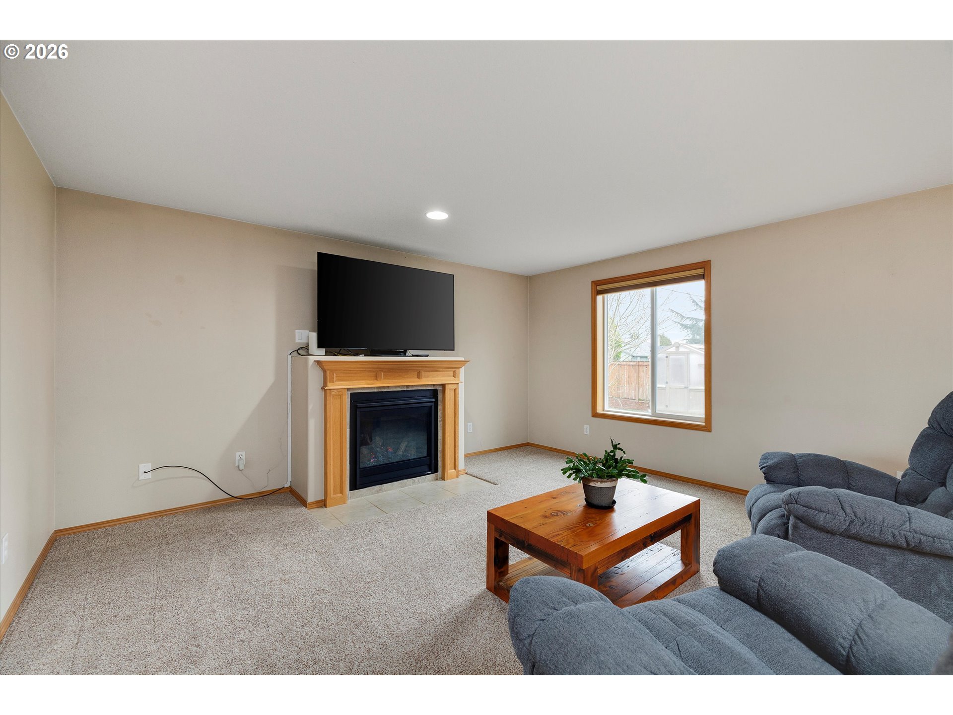 2366 Baines Boulevard Hubbard, OR 97032 - Photo 7 of 48 a living room with furniture a flat screen tv and a fireplace