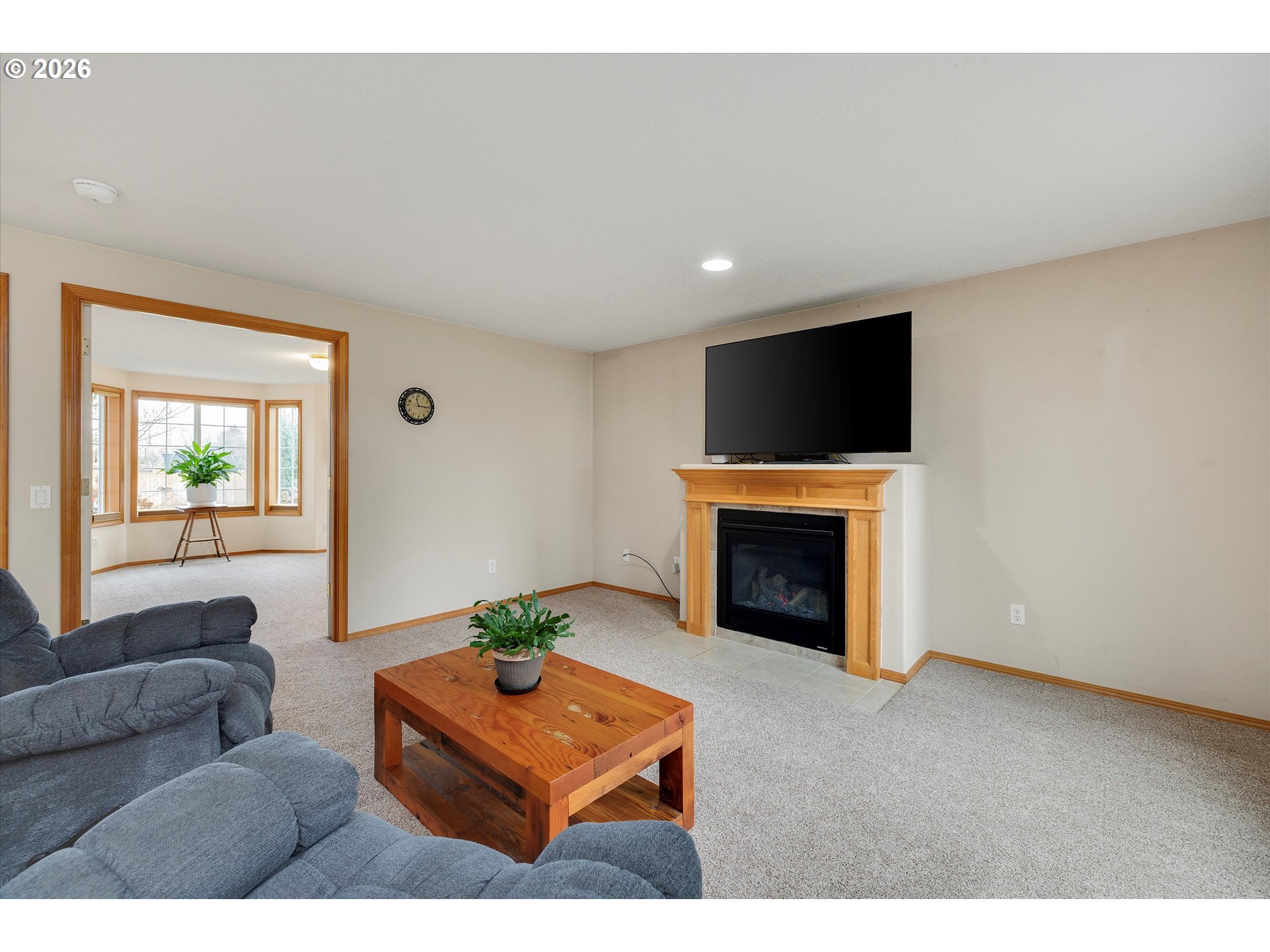2366 Baines Boulevard Hubbard, OR 97032 - Photo 9 of 48 a living room with furniture a fireplace and a flat screen tv