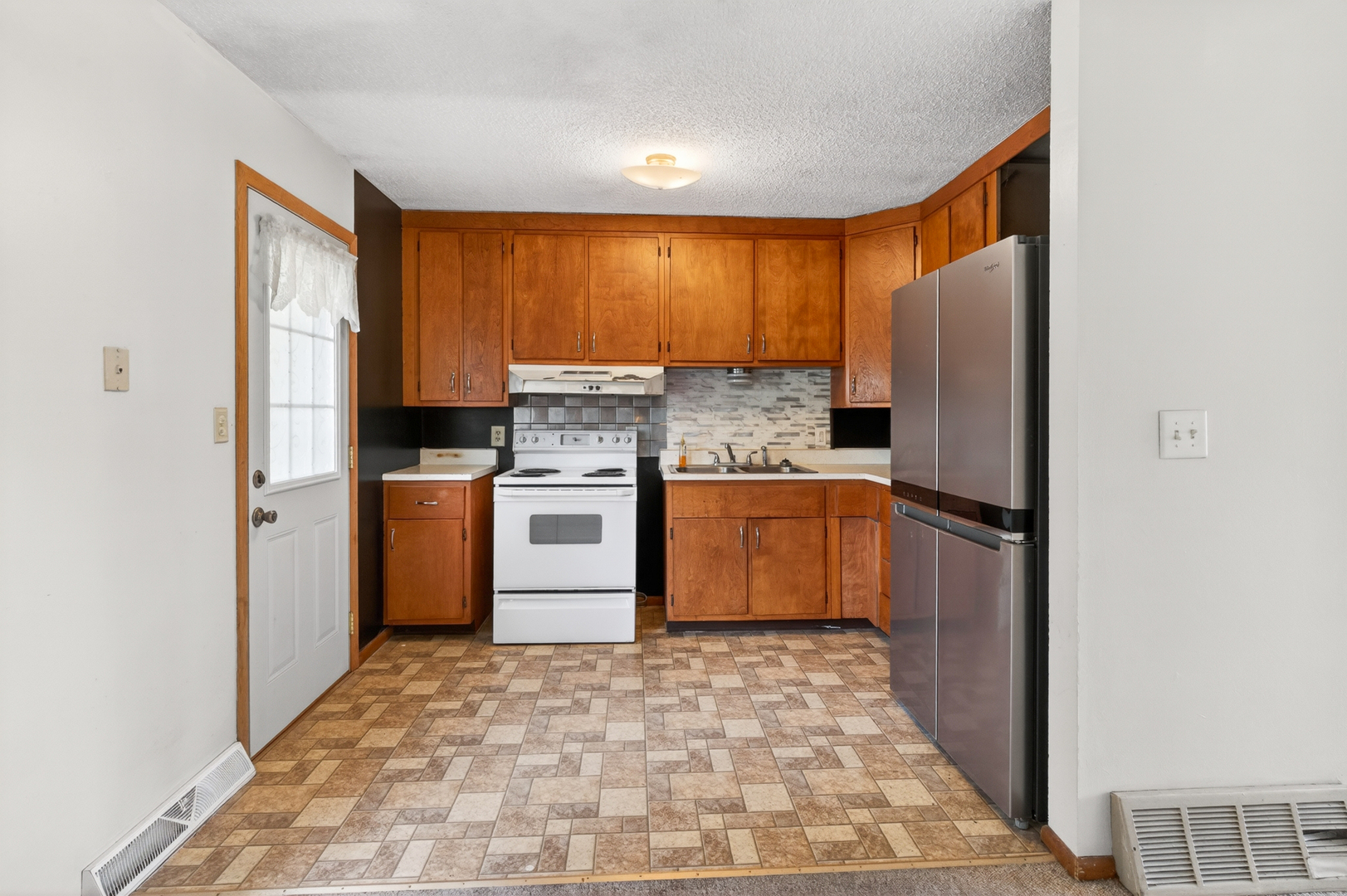 1229 13th Avenue North Clinton, IA 52732 - Photo 11 of 26 a kitchen with a stove a refrigerator and a stove top oven