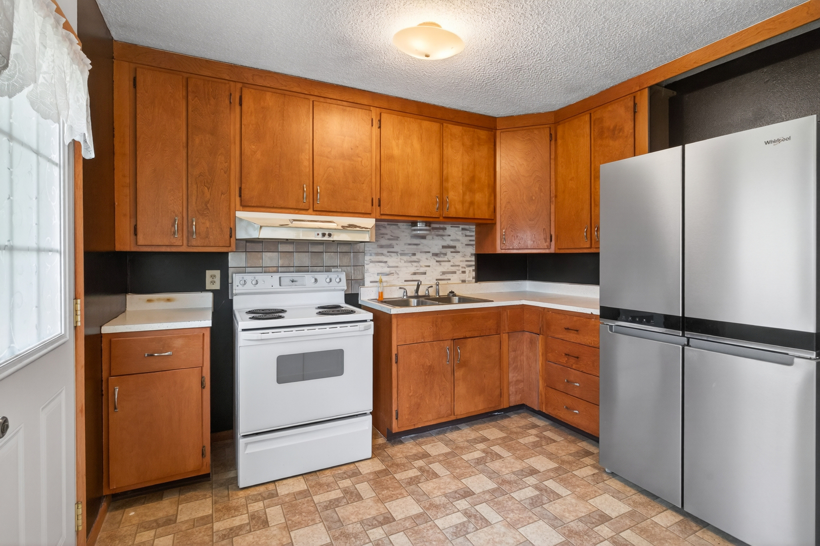 1229 13th Avenue North Clinton, IA 52732 - Photo 12 of 26 a kitchen with a refrigerator sink and cabinets