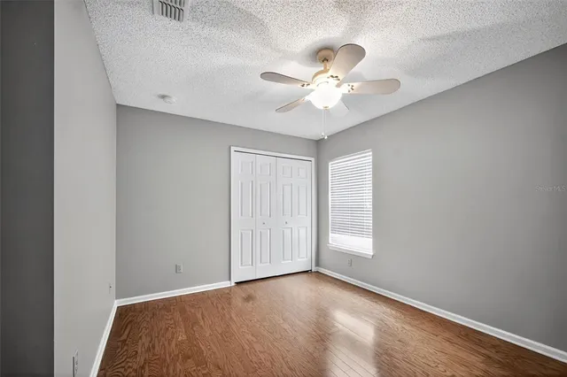 an empty room with a window and a fan