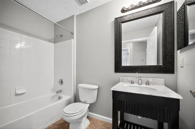 a bathroom with a granite countertop sink a toilet and shower