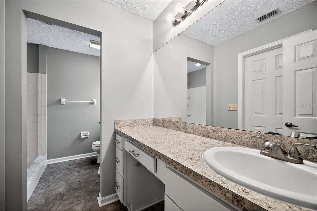 96025 Sunfish Lane Yulee, FL 32097 - Photo 14 of 17 a bathroom with a granite countertop sink a toilet and shower