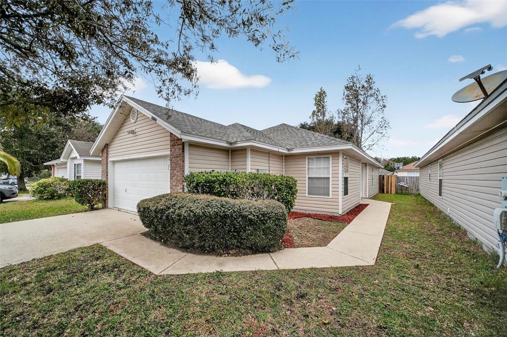 96025 Sunfish Lane Yulee, FL 32097 - Photo 2 of 17 a view of a house with a yard and potted plants