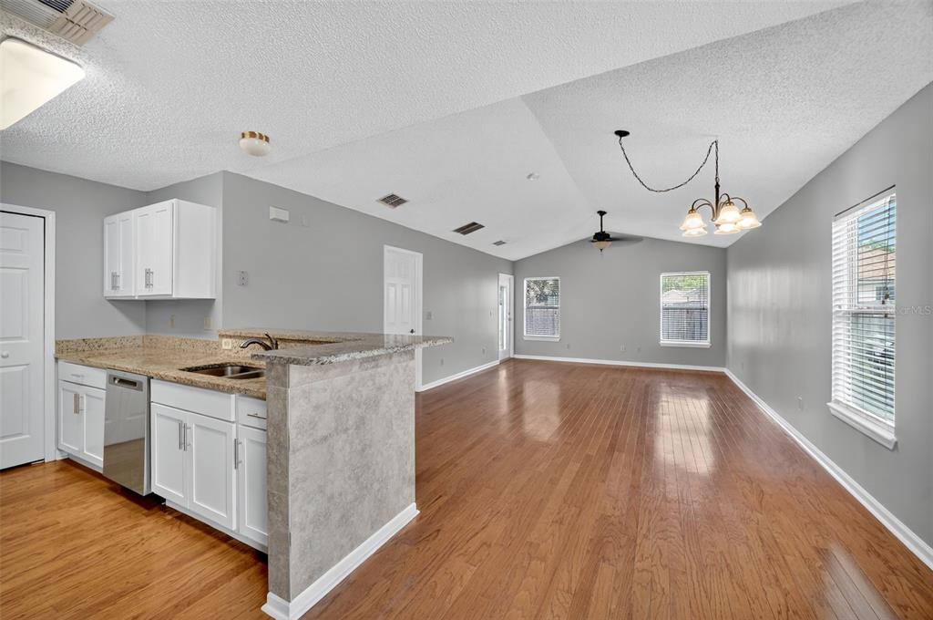 96025 Sunfish Lane Yulee, FL 32097 - Photo 7 of 17 a kitchen with granite countertop a stove and a wooden floors