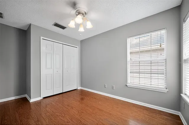 an empty room with windows and fan
