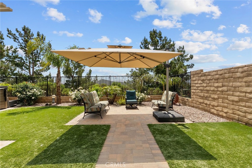 19512 Griffith Drive Saugus, CA 91350 - Photo 38 of 46 a view of a patio with couches table and chairs under an umbrella with palm trees