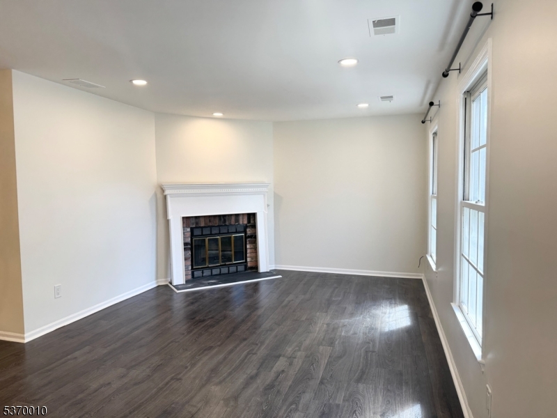 76 Jamestown Road Bernards, NJ 07920 - Photo 6 of 20 an empty room with wooden floor and fireplace
