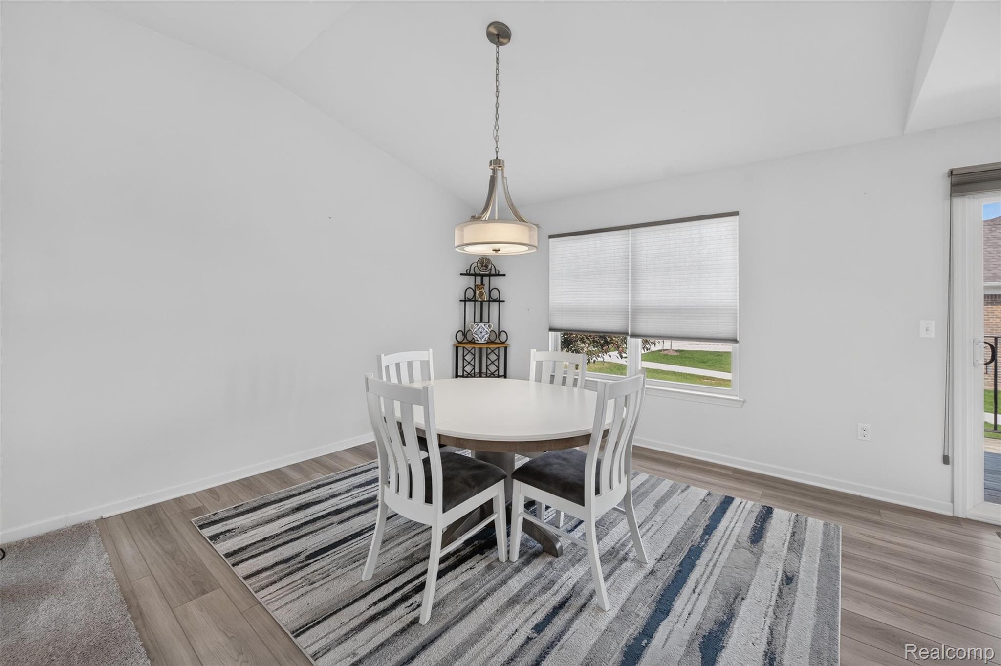 Bright dining area with plank flooring and pendant lighting.