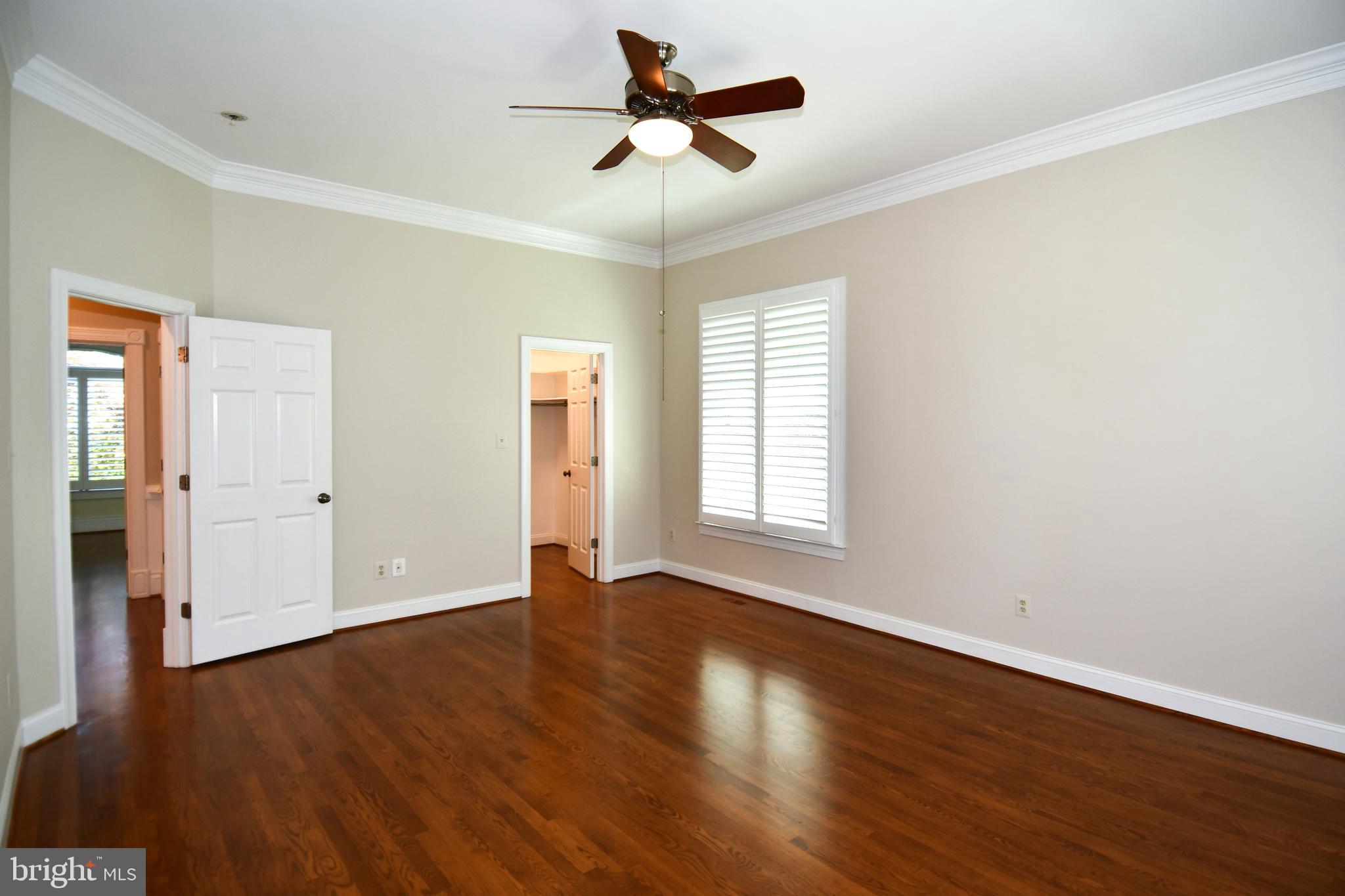 7808 Southdown Road Alexandria, VA 22308 - Photo 54 of 99 an empty room with wooden floor ceiling fan and windows