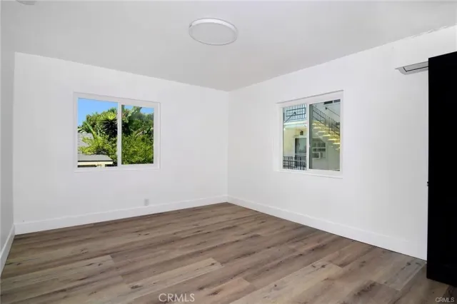 an empty room with wooden floor and window