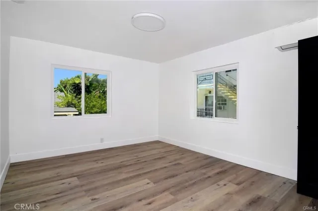 an empty room with wooden floor and window