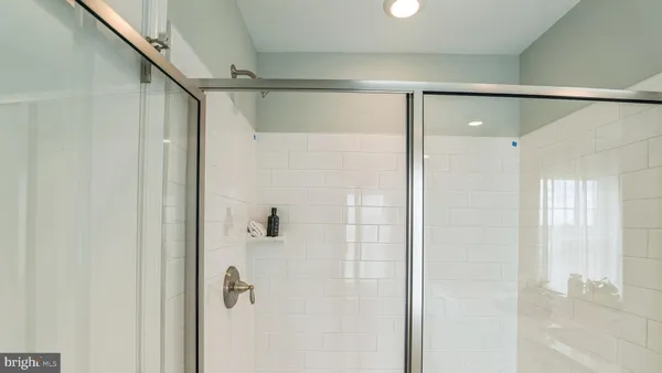 a bathroom with a glass shower door and mirror